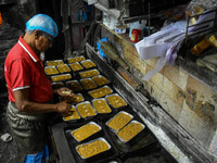 Workers make traditional fruit cake in a wood fire oven at a 100-year-old bakery ahead of Christmas celebrations in Kolkata, India, on Decem...