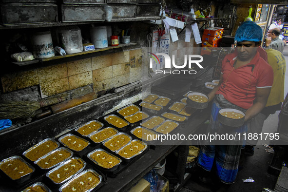 Workers make traditional fruit cake in a wood fire oven at a 100-year-old bakery ahead of Christmas celebrations in Kolkata, India, on Decem...