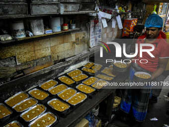 Workers make traditional fruit cake in a wood fire oven at a 100-year-old bakery ahead of Christmas celebrations in Kolkata, India, on Decem...