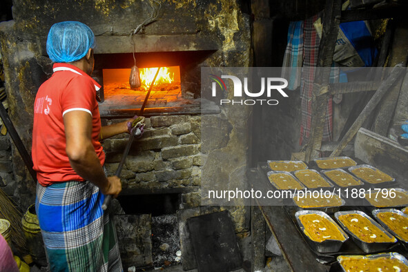 Workers make traditional fruit cake in a wood fire oven at a 100-year-old bakery ahead of Christmas celebrations in Kolkata, India, on Decem...