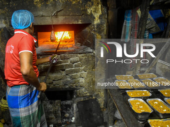 Workers make traditional fruit cake in a wood fire oven at a 100-year-old bakery ahead of Christmas celebrations in Kolkata, India, on Decem...