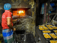 Workers make traditional fruit cake in a wood fire oven at a 100-year-old bakery ahead of Christmas celebrations in Kolkata, India, on Decem...