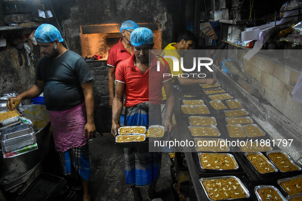 Workers make traditional fruit cake in a wood fire oven at a 100-year-old bakery ahead of Christmas celebrations in Kolkata, India, on Decem...