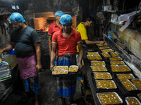 Workers make traditional fruit cake in a wood fire oven at a 100-year-old bakery ahead of Christmas celebrations in Kolkata, India, on Decem...