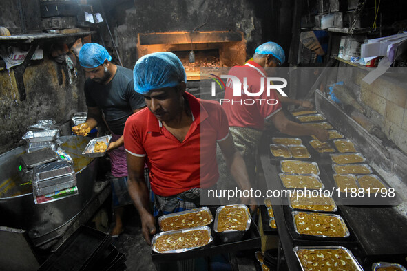 Workers make traditional fruit cake in a wood fire oven at a 100-year-old bakery ahead of Christmas celebrations in Kolkata, India, on Decem...