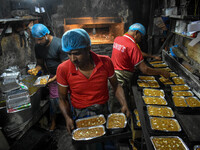 Workers make traditional fruit cake in a wood fire oven at a 100-year-old bakery ahead of Christmas celebrations in Kolkata, India, on Decem...