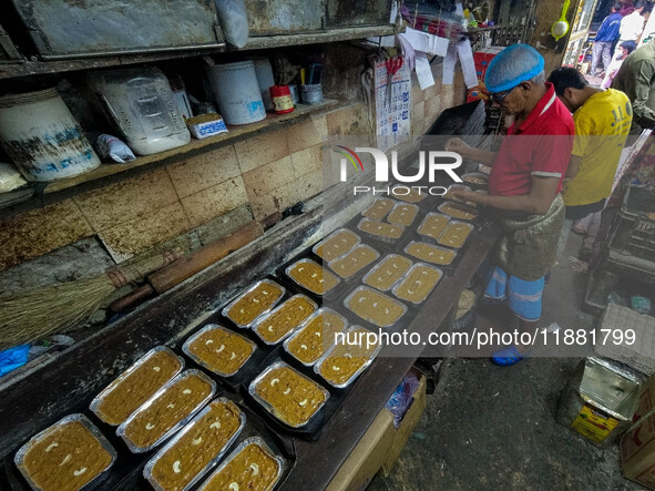 Workers make traditional fruit cake in a wood fire oven at a 100-year-old bakery ahead of Christmas celebrations in Kolkata, India, on Decem...