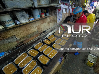 Workers make traditional fruit cake in a wood fire oven at a 100-year-old bakery ahead of Christmas celebrations in Kolkata, India, on Decem...