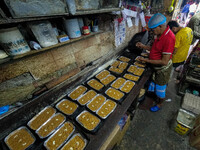 Workers make traditional fruit cake in a wood fire oven at a 100-year-old bakery ahead of Christmas celebrations in Kolkata, India, on Decem...