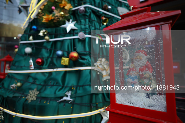 A mythical Santa Claus is on display next to the artificial Christmas tree set at the entrance of a mall in Kathmandu, Nepal, on December 19...