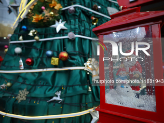 A mythical Santa Claus is on display next to the artificial Christmas tree set at the entrance of a mall in Kathmandu, Nepal, on December 19...