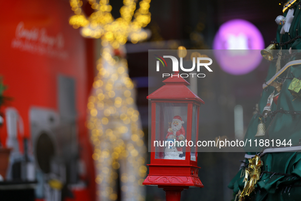 A mythical Santa Claus is on display next to the artificial Christmas tree set at the entrance of a mall in Kathmandu, Nepal, on December 19...