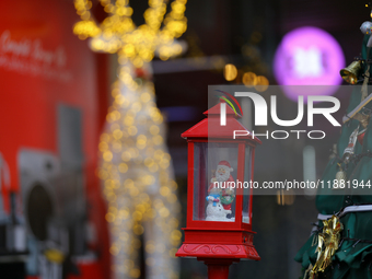 A mythical Santa Claus is on display next to the artificial Christmas tree set at the entrance of a mall in Kathmandu, Nepal, on December 19...