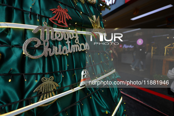 Text reading Merry Christmas is embedded in the decorations of a Christmas tree set at the entrance of a mall in Kathmandu, Nepal, on Decemb...