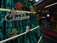 Text reading Merry Christmas is embedded in the decorations of a Christmas tree set at the entrance of a mall in Kathmandu, Nepal, on Decemb...