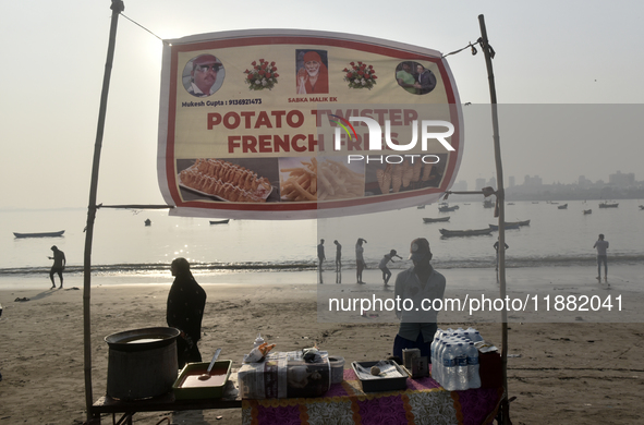 A potato twister French fry seller waits for his customer during the Mahim festival on a beach in Mumbai, India, on December 19, 2024. 