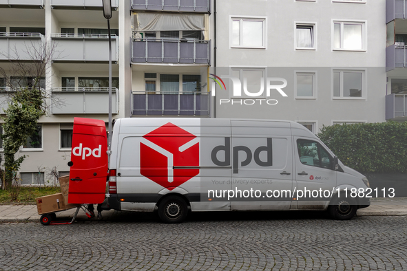 A DPD delivery van parks in front of a residential building while parcels are unloaded for delivery in Munich, Bavaria, Germany, on December...