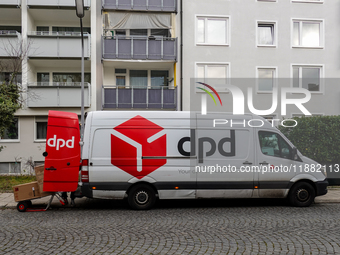 A DPD delivery van parks in front of a residential building while parcels are unloaded for delivery in Munich, Bavaria, Germany, on December...