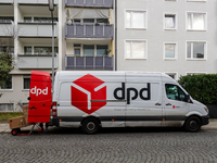 A DPD delivery van parks in front of a residential building while parcels are unloaded for delivery in Munich, Bavaria, Germany, on December...