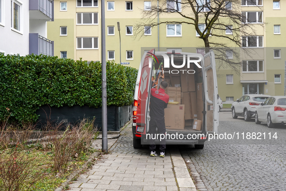 A DPD delivery van parks in front of a residential building while parcels are unloaded for delivery in Munich, Bavaria, Germany, on December...