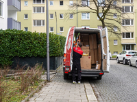 A DPD delivery van parks in front of a residential building while parcels are unloaded for delivery in Munich, Bavaria, Germany, on December...