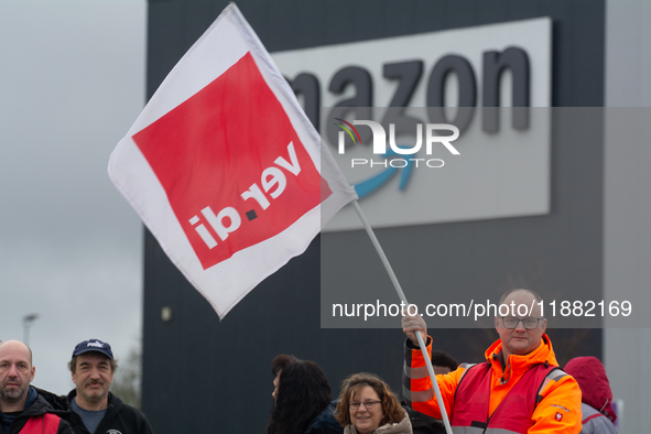 Several workers stand in front of an Amazon site in Werne, Germany, on December 19, 2024, as the Verdi labor union calls for a strike and de...