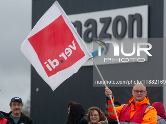 Several workers stand in front of an Amazon site in Werne, Germany, on December 19, 2024, as the Verdi labor union calls for a strike and de...