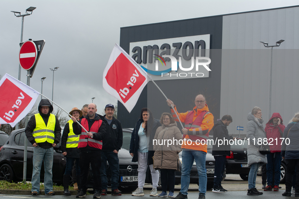 Several workers stand in front of an Amazon site in Werne, Germany, on December 19, 2024, as the Verdi labor union calls for a strike and de...