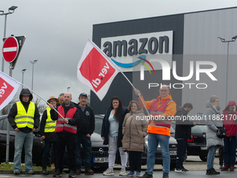 Several workers stand in front of an Amazon site in Werne, Germany, on December 19, 2024, as the Verdi labor union calls for a strike and de...