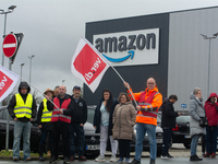 Several workers stand in front of an Amazon site in Werne, Germany, on December 19, 2024, as the Verdi labor union calls for a strike and de...