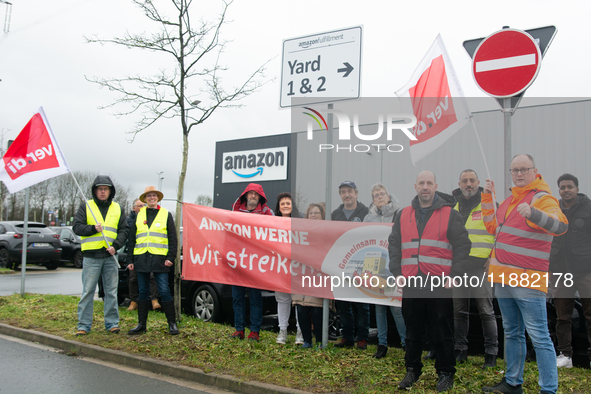 Several workers stand in front of an Amazon site in Werne, Germany, on December 19, 2024, as the Verdi labor union calls for a strike and de...