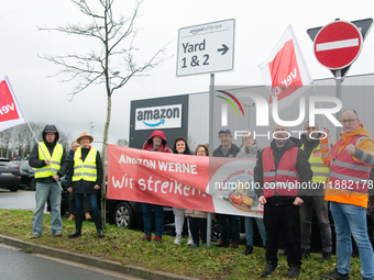 Several workers stand in front of an Amazon site in Werne, Germany, on December 19, 2024, as the Verdi labor union calls for a strike and de...