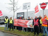 Several workers stand in front of an Amazon site in Werne, Germany, on December 19, 2024, as the Verdi labor union calls for a strike and de...