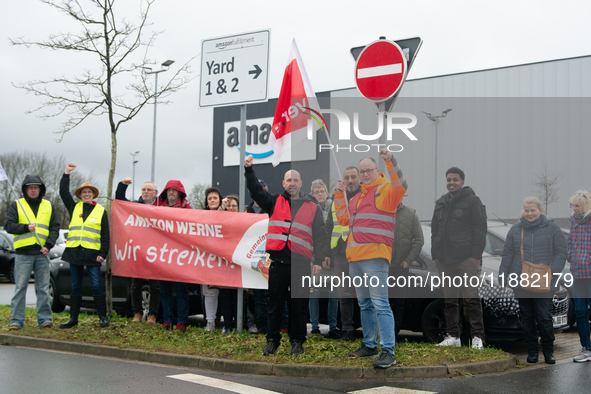 Several workers stand in front of an Amazon site in Werne, Germany, on December 19, 2024, as the Verdi labor union calls for a strike and de...