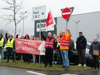 Several workers stand in front of an Amazon site in Werne, Germany, on December 19, 2024, as the Verdi labor union calls for a strike and de...