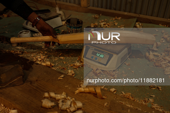 Employees work inside a Kashmir Willow bat-making factory in Bijbehara, Jammu and Kashmir, India, on December 19, 2024, on a cold winter day...