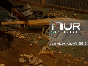 Employees work inside a Kashmir Willow bat-making factory in Bijbehara, Jammu and Kashmir, India, on December 19, 2024, on a cold winter day...