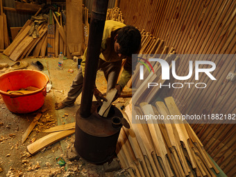 Employees work inside a Kashmir Willow bat-making factory in Bijbehara, Jammu and Kashmir, India, on December 19, 2024, on a cold winter day...