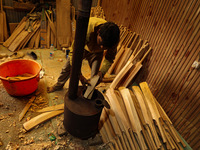 Employees work inside a Kashmir Willow bat-making factory in Bijbehara, Jammu and Kashmir, India, on December 19, 2024, on a cold winter day...