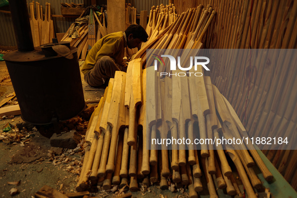 Employees work inside a Kashmir Willow bat-making factory in Bijbehara, Jammu and Kashmir, India, on December 19, 2024, on a cold winter day...