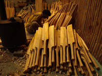 Employees work inside a Kashmir Willow bat-making factory in Bijbehara, Jammu and Kashmir, India, on December 19, 2024, on a cold winter day...