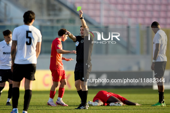 In Ta' Qali, Malta, on December 14, 2024, Malta FA and FIFA International soccer referee Trustin Farrugia Cann shows a yellow card to a Hibe...