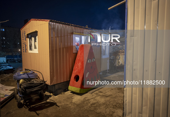 A watermelon-shaped doll is placed next to a container at a construction site during the pomegranate festival on Yalda Night Eve in the Abas...