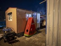 A watermelon-shaped doll is placed next to a container at a construction site during the pomegranate festival on Yalda Night Eve in the Abas...