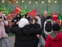 Iranian people stand in front of Yalda decorations during a pomegranate festival on Yalda Night Eve in the Abasabad tourism zone in central...