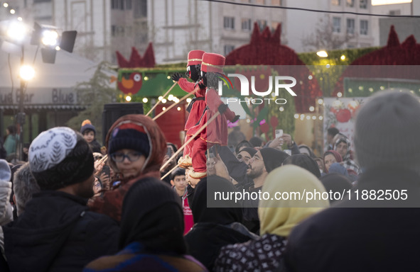 Young puppeteers perform with two Iranian traditional puppets during a pomegranate festival on Yalda Night Eve in the Abasabad tourism zone...