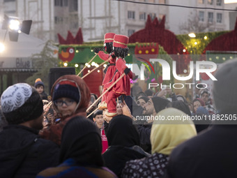 Young puppeteers perform with two Iranian traditional puppets during a pomegranate festival on Yalda Night Eve in the Abasabad tourism zone...