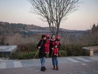 Two young female puppeteers pose for a photograph with two Iranian traditional puppets during a pomegranate festival on Yalda Night Eve in t...