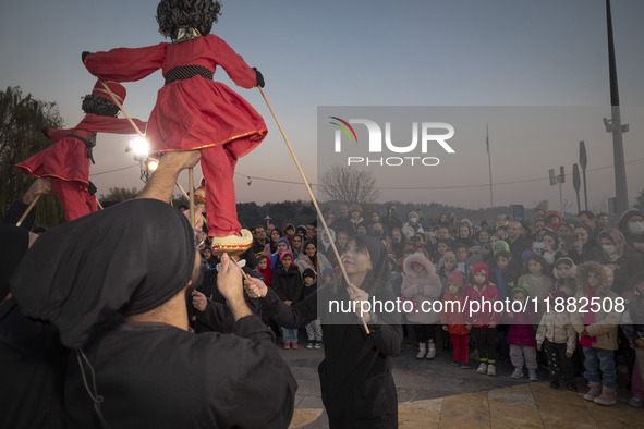 Young puppeteers perform with two Iranian traditional puppets during a pomegranate festival on Yalda Night Eve in the Abasabad tourism zone...