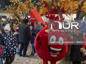 Iranian families pose for photographs with pomegranate and watermelon-shaped dolls during a pomegranate festival on Yalda Night Eve in the A...